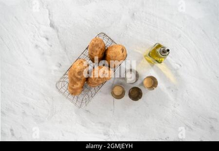 Pose à plat. Ingrédient pour préparer des quartiers de pommes de terre cuits avec des épices sur le comptoir. Banque D'Images