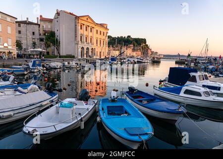 Port de Piran avec des bateaux au coucher du soleil . Banque D'Images