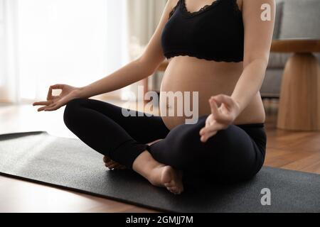 Gros plan de la femme enceinte faire des exercices prénatals de yoga méditer Banque D'Images