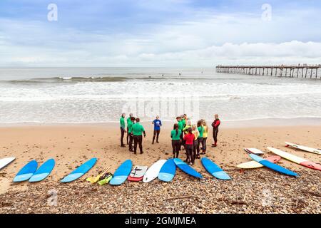 École de surf avec instructeur, élèves et planches de surf sur la plage à Saltburn by the Sea, Redcar et Cleveland District, North Yorkshire, Angleterre, Banque D'Images