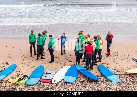 École de surf avec instructeur, élèves et planches de surf sur la plage à Saltburn by the Sea, Redcar et Cleveland District, North Yorkshire, Angleterre, Banque D'Images