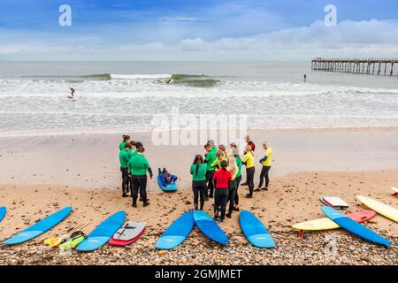 École de surf avec instructeur, élèves et planches de surf sur la plage à Saltburn by the Sea, Redcar et Cleveland District, North Yorkshire, Angleterre, Banque D'Images