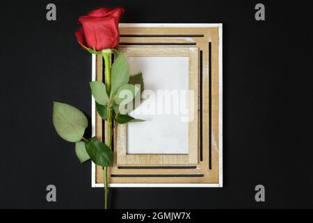 Carte de condoléances avec cadre maquette et rose rouge sur fond noir Banque D'Images