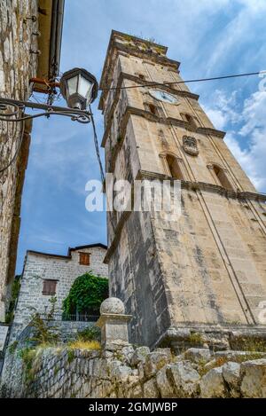 Le clocher haut, étroit et distinctif de l'église catholique de Saint-Nicolas domine la ville hisrorique, à la fin de l'été, sous le soleil. Banque D'Images