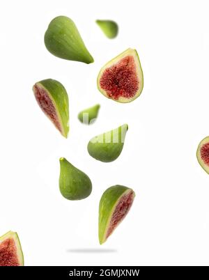 Figues vertes mûres entières et tranchées dans l'air sur fond blanc Banque D'Images