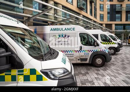 Cinq ambulances stationnées à l'extérieur sur la piste et la canopée du bâtiment Brunel de l'hôpital NHS Southmead de Bristol. Banque D'Images