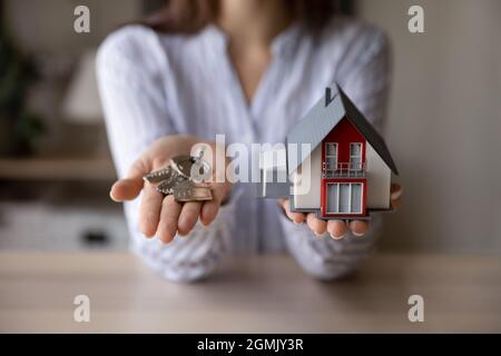 Crop close up femme Realtor tenant des clés et modèle de maison Banque D'Images