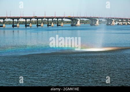 Arc-en-ciel sur les ruisseaux de la fontaine sur le fond du pont au-dessus de la rivière Dniepr. Les jets d'eau sont réfléchis comme un arc-en-ciel de Banque D'Images