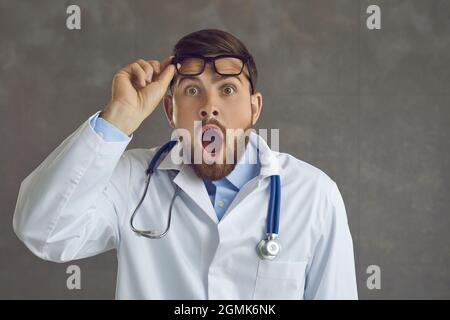 Portrait d'un jeune médecin surpris regardant loin avec une drôle d'expression de visage choqué Banque D'Images