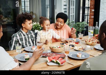 Portrait d'une grande famille afro-américaine en train de dîner ensemble à l'extérieur et souriant avec joie Banque D'Images