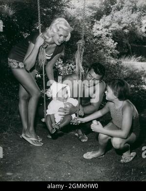 1959 - Garrads Cross, Angleterre, Royaume-Uni - sur l'oscillation, Baby MIKLOS HARGITAY obtient l'encouragement de toute la famille alors qu'il se prépare à embarquer sur son premier swing. Acteur JAYNE MANSFIELD, à gauche, son mari MICKEY HARGITAY, leur nouvelle arrivée, bébé Miklos, Et la fille de Mansfield de son premier mariage JAYNE MARIE, à droite, s'est déplacée dans la maison de campagne de 18 le siècle de l'acteur H. Gregg tandis que Mansfield a joué son rôle dans un film carrelé ''trop chaud pour manipuler'' étant faite ici. (Image de crédit : © Keystone Press Agency/ZUMA Wire) Banque D'Images