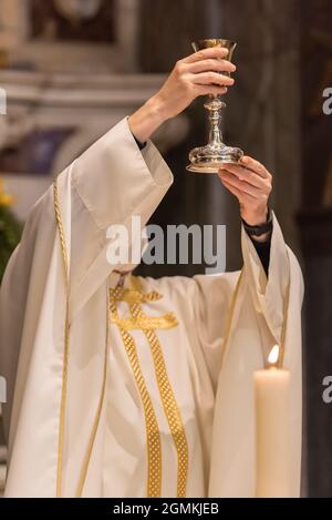 L'élévation du Goblet avec le vin sacramentel pendant la Liturgie catholique de l'Eucharistie Banque D'Images