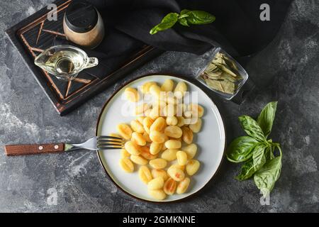 Assiette avec gnocchi savoureux sur fond sombre Banque D'Images