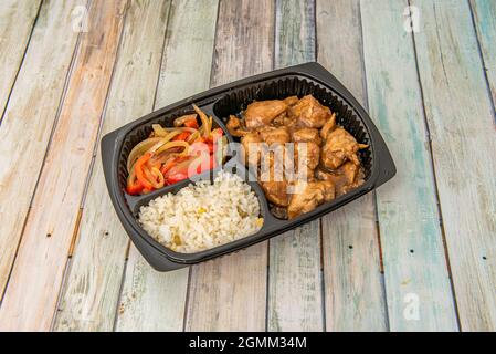 plateau à emporter fajita poulet fusion sauce teriyaki avec riz blanc et bandes d'oignons et de poivrons rasés Banque D'Images