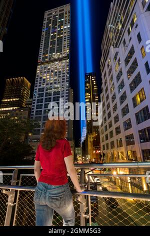 9/11 hommage à la lumière. Lower Manhattan illuminé la nuit. Femme regardant Washington Street. Vue depuis Liberty Park, Manhattan, États-Unis.