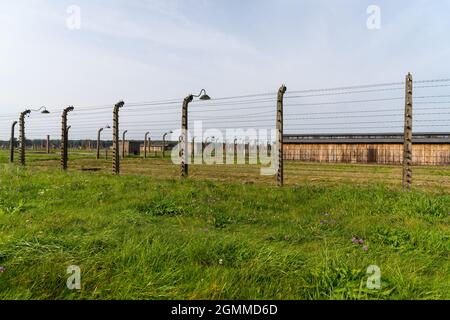 Auschwitz, Pologne - 15 septembre 2021 : des clôtures grillagées barbelées entourent les casernes de prisonniers dans le camp de concentration d'Auschwitz Banque D'Images