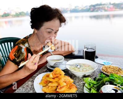 Banh Tom (gâteau vietnamien aux crevettes frites) est un plat populaire de la rue à Hanoi, Vietnam. Banque D'Images