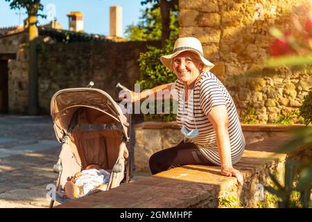 Grand-mère avec le petit-fils dans le village médiéval de Pals au coucher du soleil Banque D'Images