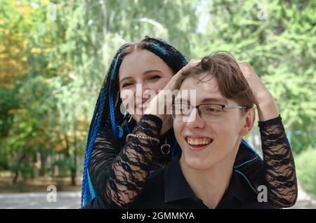 Bonne femme souriante, piquant sur son petit ami. Jeune adulte m Banque D'Images