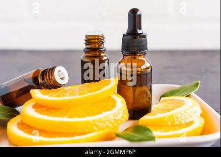 Sérum rajeunissant et essentielle de mslo d'orange en flacons de verre. Huile d'agrumes, orange naturel, vitamine C. Banque D'Images