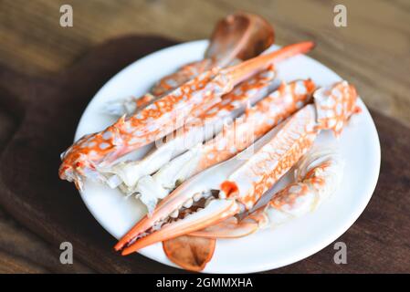 Crabe bouilli sur plaque blanche sur la table, pinces de crabe fruits de mer, crabe bleu nageur Banque D'Images