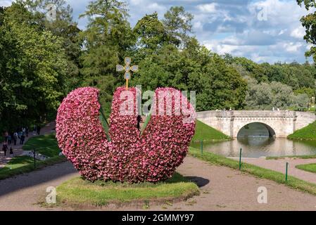 Gatchina, région de Leningrad, Russie - 18 août 2021 : sculpture de fleurs de la couronne impériale et pont de Carp et étang de Carp en arrière-plan. Banque D'Images