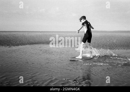 Un jeune garçon de 12 ans arnaque à West Wittering Beach, Chichester, West Sussex, Angleterre, Royaume-Uni, Angleterre, Royaume-Uni. Banque D'Images