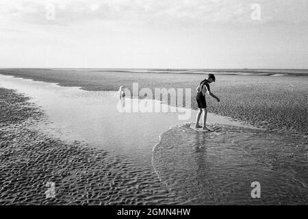 Un jeune garçon de 12 ans arnaque à West Wittering Beach, Chichester, West Sussex, Angleterre, Royaume-Uni, Angleterre, Royaume-Uni. Banque D'Images