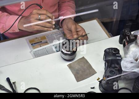 Le technicien répare la lentille de la caméra à l'atelier de réparation Banque D'Images