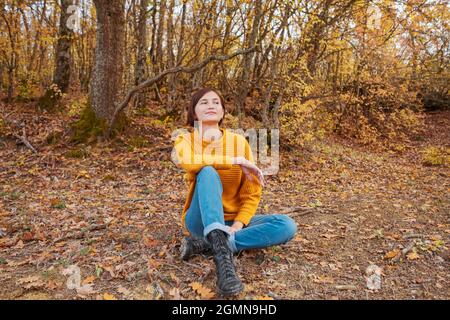 Femme en randonnée regardant la vue panoramique du paysage de montagne de feuillage d'automne. Aventure en plein air dame de voyage assis se détendre dans la nature en automne saison. Banque D'Images