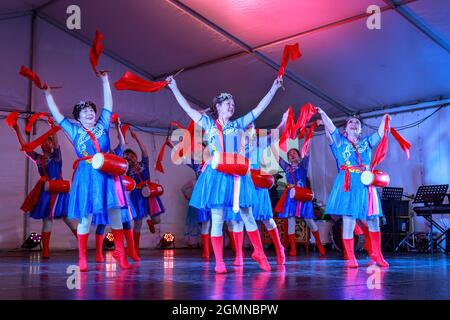 Des femmes chinoises dansent sur scène avec des foulards et des tambours de taille pendant les célébrations du festival Moon (mi-automne). Auckland, Nouvelle-Zélande Banque D'Images