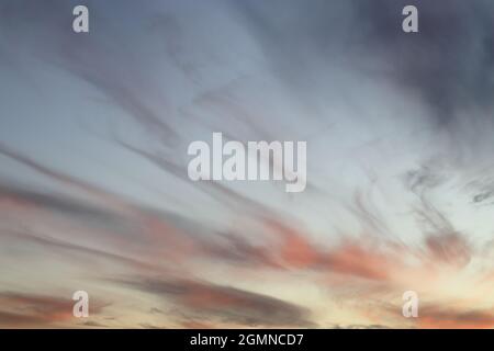 Ciel au coucher du soleil avec des bandes de nuages roses et orange Banque D'Images