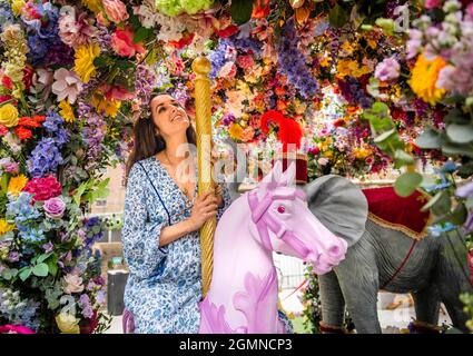 USAGE ÉDITORIAL SEULEMENT juge de la concurrence, Rosanna Falconer examine une installation de carrousel floral dans Halkin Arcade, qui a été conçu par les fleuristes Neill Strain et Judith Blacklock pour le festival Belgravia in Bloom, qui se tiendra du 20 au 26 septembre à Londres. Date de la photo: Lundi 2021 septembre. Banque D'Images