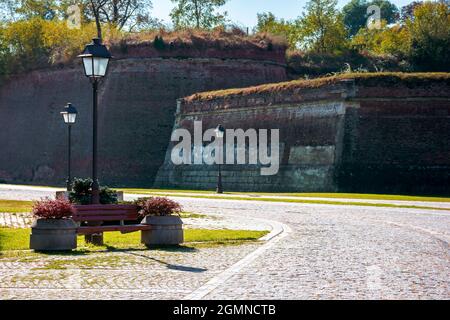 alba-iulia, roumanie - OCT 13, 2019: Les rues intérieures de la citadelle de la Caroline de l'Alba en automne. Les lanternes et les bancs près de la passerelle. Les immenses murs autour du chemin. Banque D'Images