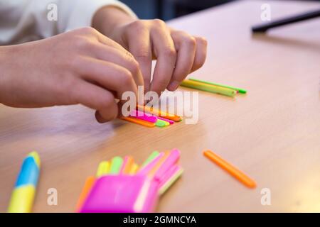 Les mains des élèves en gros plan sont comptées avec des bâtons mathématiques. Un écolier effectue une tâche sur le lieu de travail. Le concept de l'éducation, de l'enseignement des connaissances, des compétences et des capacités des enfants. Banque D'Images