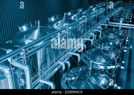 Une microbrasserie privée à l'intérieur moderne et artisanale de production de bière. Rangée de cuves de micro brasserie en métal brillant. Banque D'Images