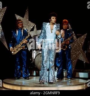 Garry Glitter, geboren als Paul Francis Gadd, bekannt auch als Paul Raven, britischer Glamrock Musiker, BEI einem Auftritt mit Band vers 1974. Garry Glitter né Paul Francis Gadd, également connu sous le nom de Paul Raven, musicien de rock glam britannique, qui se présente avec le groupe vers 1974. Banque D'Images