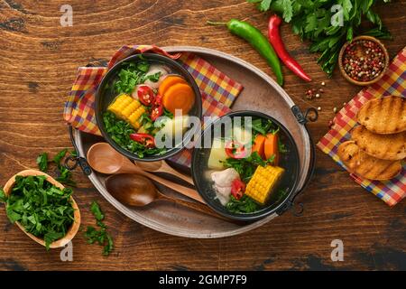 Soupe de viande chilienne avec pamkine, maïs, coriandre fraîche et pommes de terre sur fond de table en bois. Cazuela. Cuisine latino-américaine. Banque D'Images