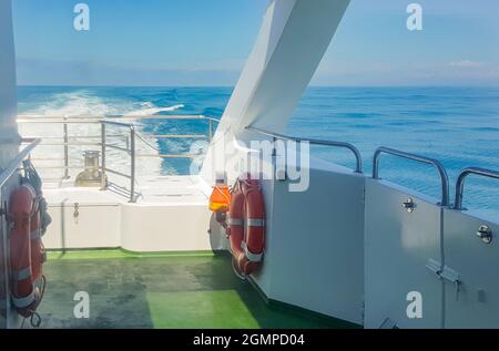 Une bouée de sauvetage sur le pont d'un yacht de luxe, une vue sur la mer avec des vagues, un sentier sur l'eau, le concept d'un séjour sur l'eau et un TR romantique Banque D'Images