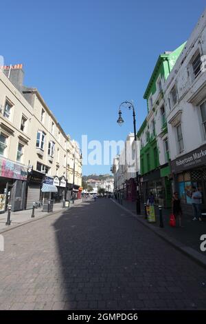 Robertson Street à Hastings (America Ground) avec ses boutiques et ses cafés et vue sur le château normand, Hastings, East Sussex, Royaume-Uni Banque D'Images