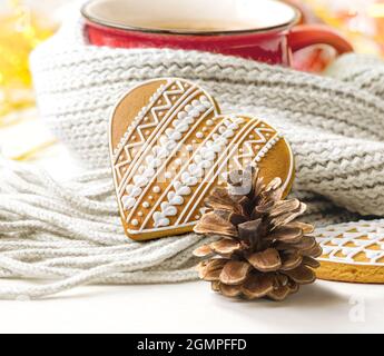 Tasse de thé couverte d'une écharpe chaude avec un cône de pin et une branche de sapin. Banque D'Images