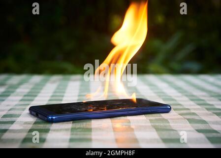 Le téléphone portable explose et brûle.Explosion et incendie du téléphone cellulaire.Smartphone danger en cas d'utilisation excessive ou de mauvaise fabrication.Surchauffe en surchauffe Banque D'Images