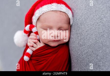 Nouveau-né dormant avec des friandises de noël tricotées Banque D'Images