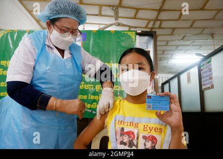 Phnom Penh. 20 septembre 2021. Le 20 septembre 2021, une fille reçoit sa première dose du vaccin COVID-19 dans un centre d'inoculation à Phnom Penh, au Cambodge. POUR ALLER AVEC 'Roundup: Le Cambodge inocule 75 population pct contre COVID-19' crédit: Phearum/Xinhua/Alamy Live News Banque D'Images