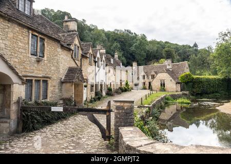 Les pittoresques cottages traditionnels en pierre le long du pont de la rivière Brook, dans le village préservé de Castle Combe, Wiltshire, Angleterre, Royaume-Uni Banque D'Images