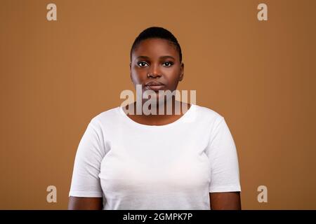 Portrait d'une jeune femme noire chubby sérieuse et décontractée Banque D'Images