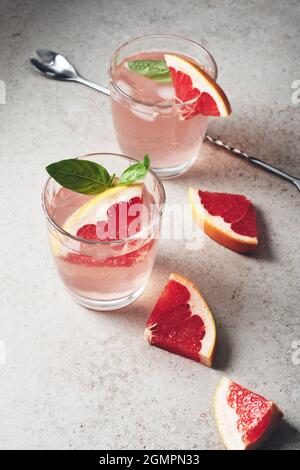 Deux verres de pamplemousse à faible teneur en alcool et au basilic. Banque D'Images