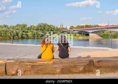 Jeunes femmes regardant le fleuve vers le quartier de Praga, Bulwar Karskiego, Wisła Bulwary, promenades au bord de la rivière, Varsovie, Pologne Banque D'Images