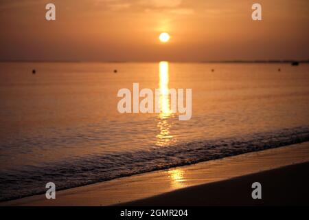 Grand soleil jaune se coucher sur la surface de la mer. Banque D'Images