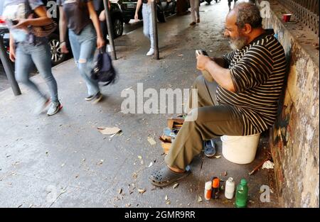 Beyrouth, Liban. 20 septembre 2021. Un nettoyeur de chaussures de rue au travail à Beyrouth, au Liban, le lundi 20 2021 septembre. Lundi également, le nouveau ministère des Finances a déclaré que le Liban recevra jeudi 1.135 milliards de dollars du programme des droits de tirage spéciaux du FMI. L'injection de fonds intervient lorsque les réserves de la banque centrale libanaise sont très pauvres. Le gouvernement n'a pas encore déclaré comment les fonds seront utilisés. (ELISA Gestri/Sipa USA) Credit: SIPA USA/Alay Live News Banque D'Images